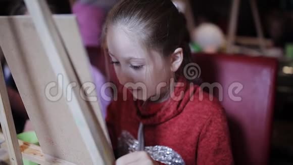 一个漂亮的小女孩正在画布上画一幅画早期开发工作室艺术工作室视频的预览图