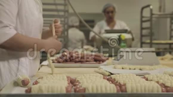 关闭食品工业的加工场景食品厂的工人用面团生产香肠视频的预览图