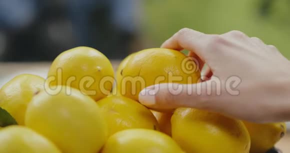 手拿鲜黄柠檬在水果店视频的预览图