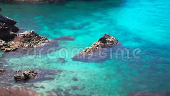 明亮清澈的绿松石水有珊瑚礁和岩石视频的预览图