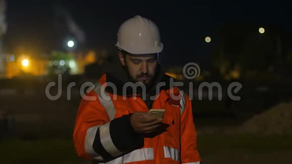 在暮色中使用智能手机的工人夜班概念4k视频的预览图