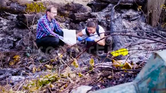 两位科学家生态学家在森林被烧毁的地方工作视频的预览图