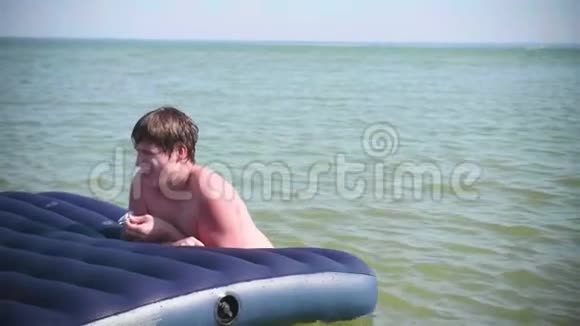 一个年轻人在充气床垫上游泳积极的情绪夏日炎炎视频的预览图