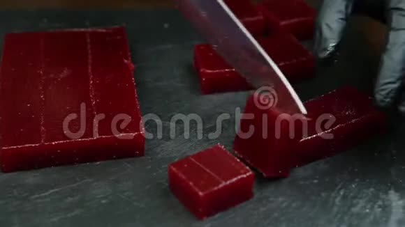 糖果用刀子把深红色的果酱切成小块视频的预览图