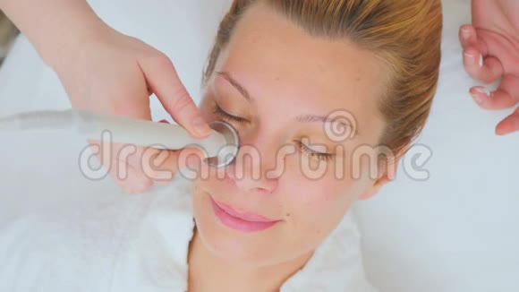 年轻女子在美容诊所享受超声波面部按摩视频的预览图