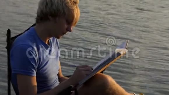 年轻人在尼斯河畔的记事本上乱写乱画视频的预览图