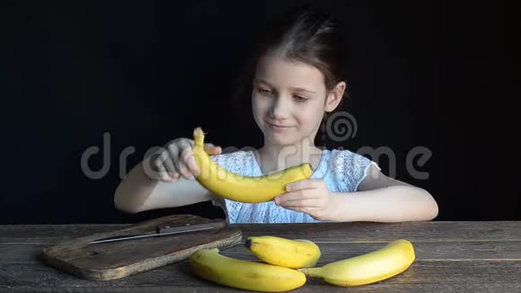 那个女孩把香蕉切在一块砧板上视频的预览图