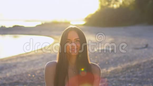 美丽的女人在海滩上缓慢地吹着纸屑白种人快乐的少女吹金闪闪视频的预览图