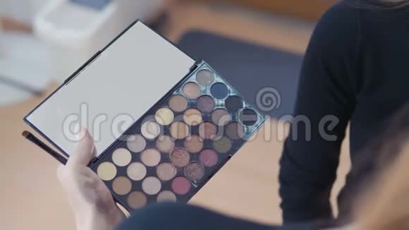 化妆工具刷子铺设在彩色化妆品调色板上视频的预览图