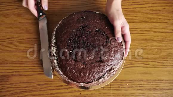 女人手工切割海绵蛋糕烹饪蛋糕顶部视图视频的预览图