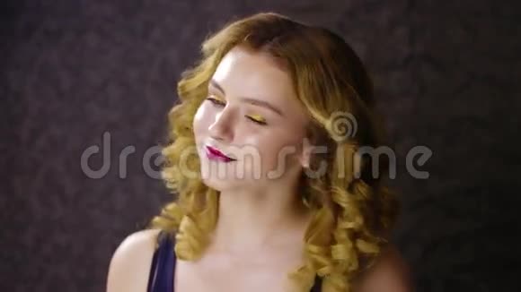 美丽的金发女孩卷发和顶部微笑黑暗的背景视频的预览图