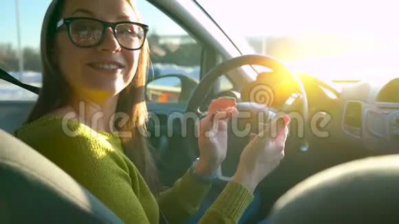 戴眼镜的女人用智能手机和车里的人说话视频的预览图