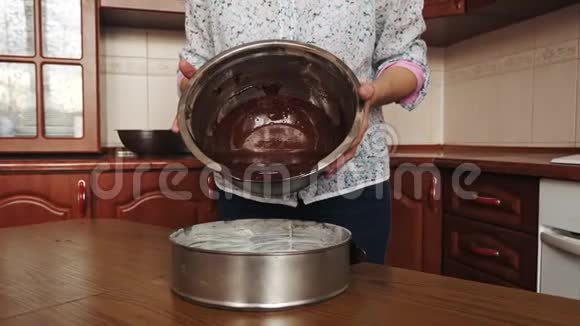 巧克力面团倒入烤盘女人把面团倒进圆形烤盘里视频的预览图