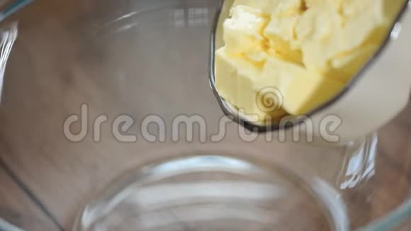 一个女人把一块黄油放进碗里特写视频的预览图