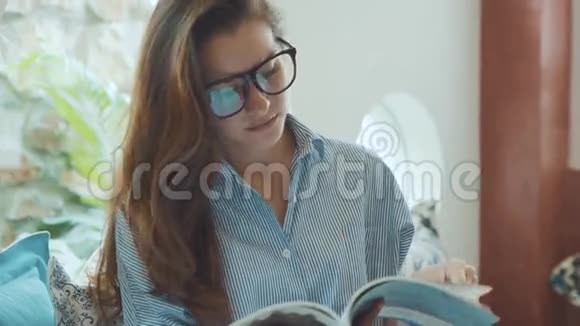 年轻女子在酒店的沙发上看杂志视频的预览图