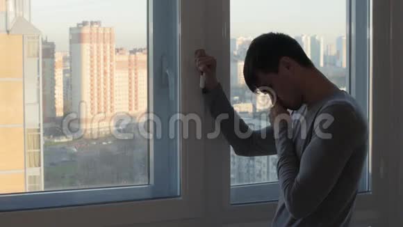 担心的人站在窗边哭泣视频的预览图