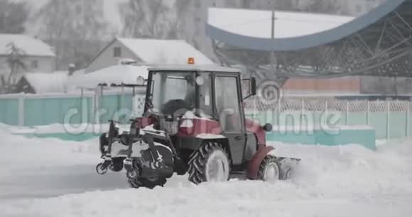 拖拉机在城市的冬季雪日清扫积雪冬季工作用车除雪车视频的预览图