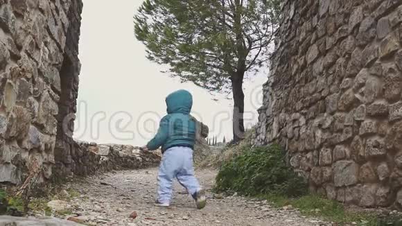 一岁的婴儿走在山上的废墟旧城堡附近西班牙朗达视频的预览图