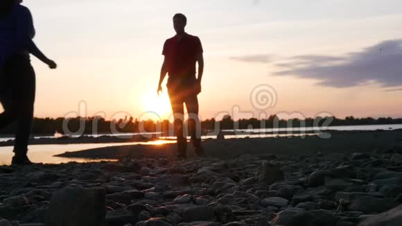 在河边美丽的日落背景下女孩跑过去拥抱她的男朋友高清1920x1080视频的预览图