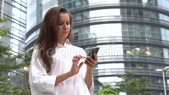 穿着严肃的女商人在智能手机上工作视频的预览图
