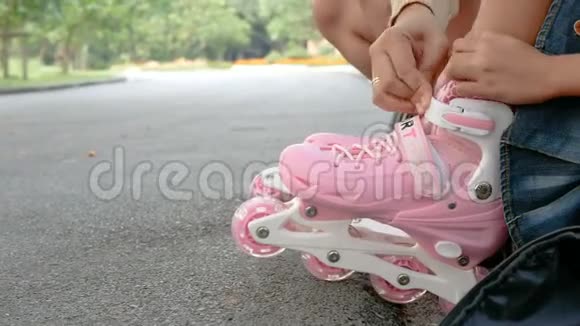 特写镜头小女孩和母亲穿着溜冰鞋在自然公园视频的预览图