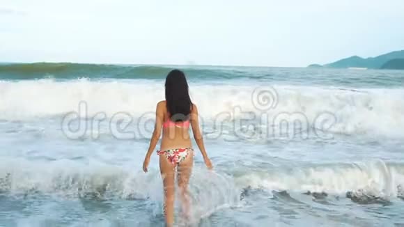 夏天站在海滩上的女人亚洲女孩出海举起双手视频的预览图