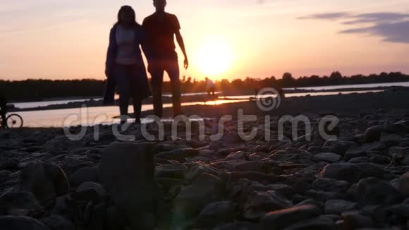 一对相爱的夫妇在浪漫的夜晚漫步在河岸日落高清1920x1080慢动作视频的预览图