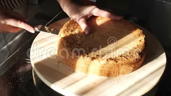 女人手工切割海绵蛋糕家庭烘焙海绵蛋糕躺在餐桌上视频的预览图