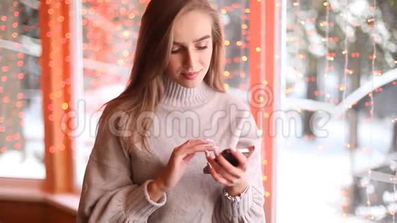 年轻漂亮的女人在智能手机上发短信或使用互联网博克背景视频的预览图