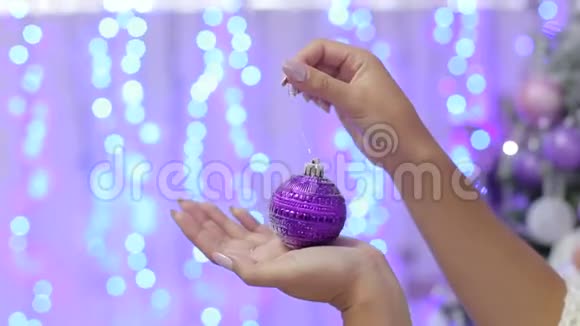 一个女孩拿着紫色的圣诞球特写视频的预览图