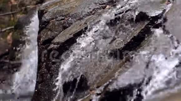 美丽的瀑布在山上流淌在潮湿的岩石中隐藏的瀑布视频的预览图