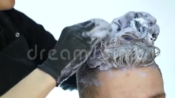 理发师做头发突出头发着色的男性客户慢动作视频的预览图