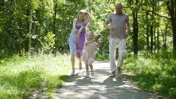 幸福的家庭小女孩正向公园里的摄像机跑去慢镜头视频的预览图