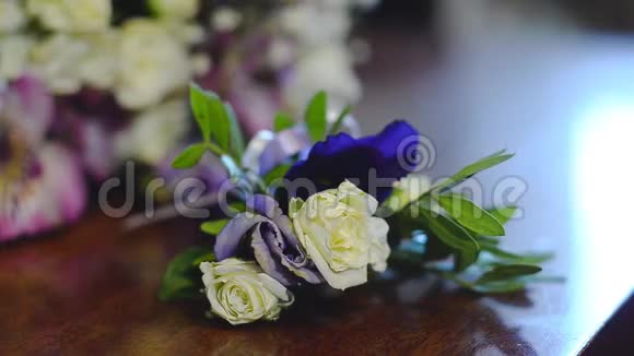 桌上摆着一束白色和蓝色的花一个人手里拿着一朵美丽的五颜六色的花视频的预览图