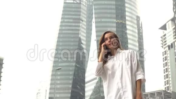 女商人接电话收到好消息兴奋快乐开朗胜利的姿态商业区摩天大楼视频的预览图