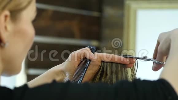 女理发师在美容店里用剪刀剪发慢动作视频的预览图