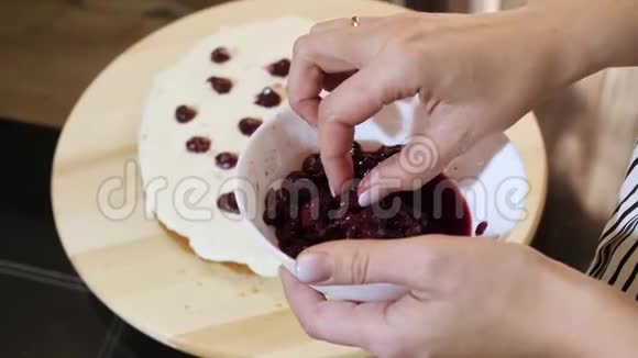 女人的手放奶油蛋糕一个樱桃特写视频的预览图