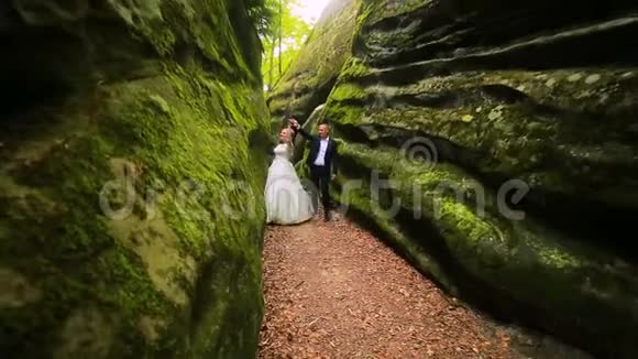 一对漂亮的岩石背景一对站在山下的夫妇视频的预览图