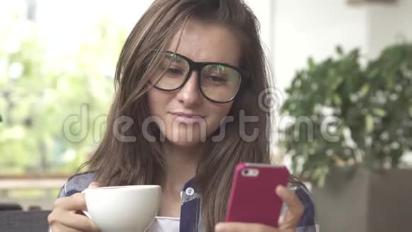 年轻女子喝咖啡用手机发信息视频的预览图