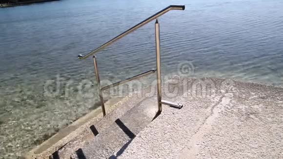 游泳扶手和海滩楼梯钢扶手游泳蓝海海边海浪夏天旅游视频的预览图