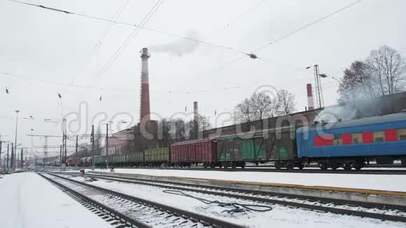 冬季灰色天空背景下火车在火车站缓慢行驶视频的预览图