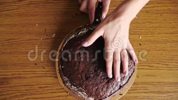 女人手工切割海绵蛋糕烹饪蛋糕顶部视图视频的预览图