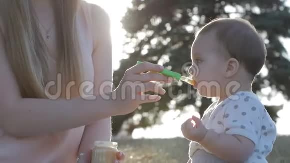在耀斑日落时母亲缓慢地喂女儿吃蔬菜视频的预览图