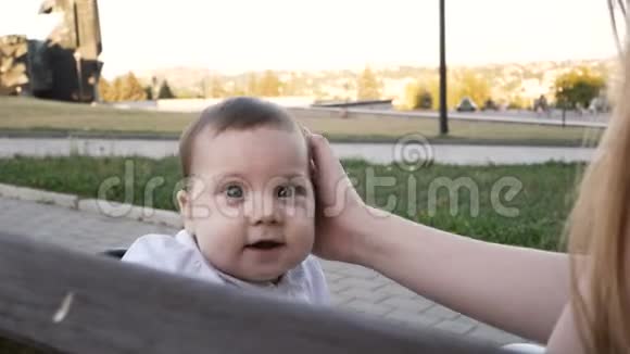 公园里坐在长凳上的快乐女婴视频的预览图