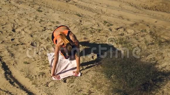 苗条的运动女士在沙滩上锻炼腹肌视频的预览图