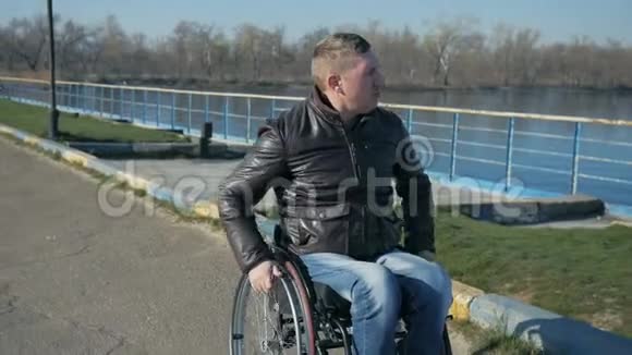 瘸子骑着轮椅在河边的桥上骑着男性肖像在视频的预览图