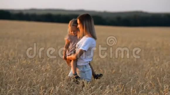 美丽的年轻母亲和女儿在麦田里玩得很开心视频的预览图