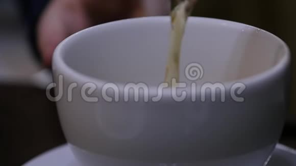 在咖啡馆里将浓茶倒入白杯中慢动作视频的预览图