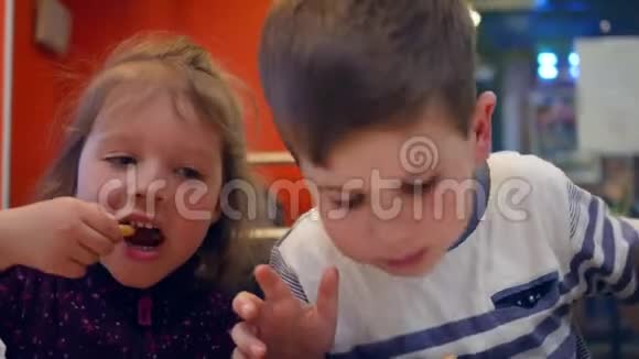 活泼有趣的孩子在快餐店吃饭男孩子用餐巾擦脸可爱的兄妹视频的预览图