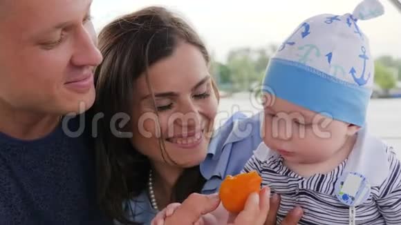 家庭游艇宝宝吃手中的第一个水果妈妈周末有孩子的家庭父母和孩子快乐视频的预览图